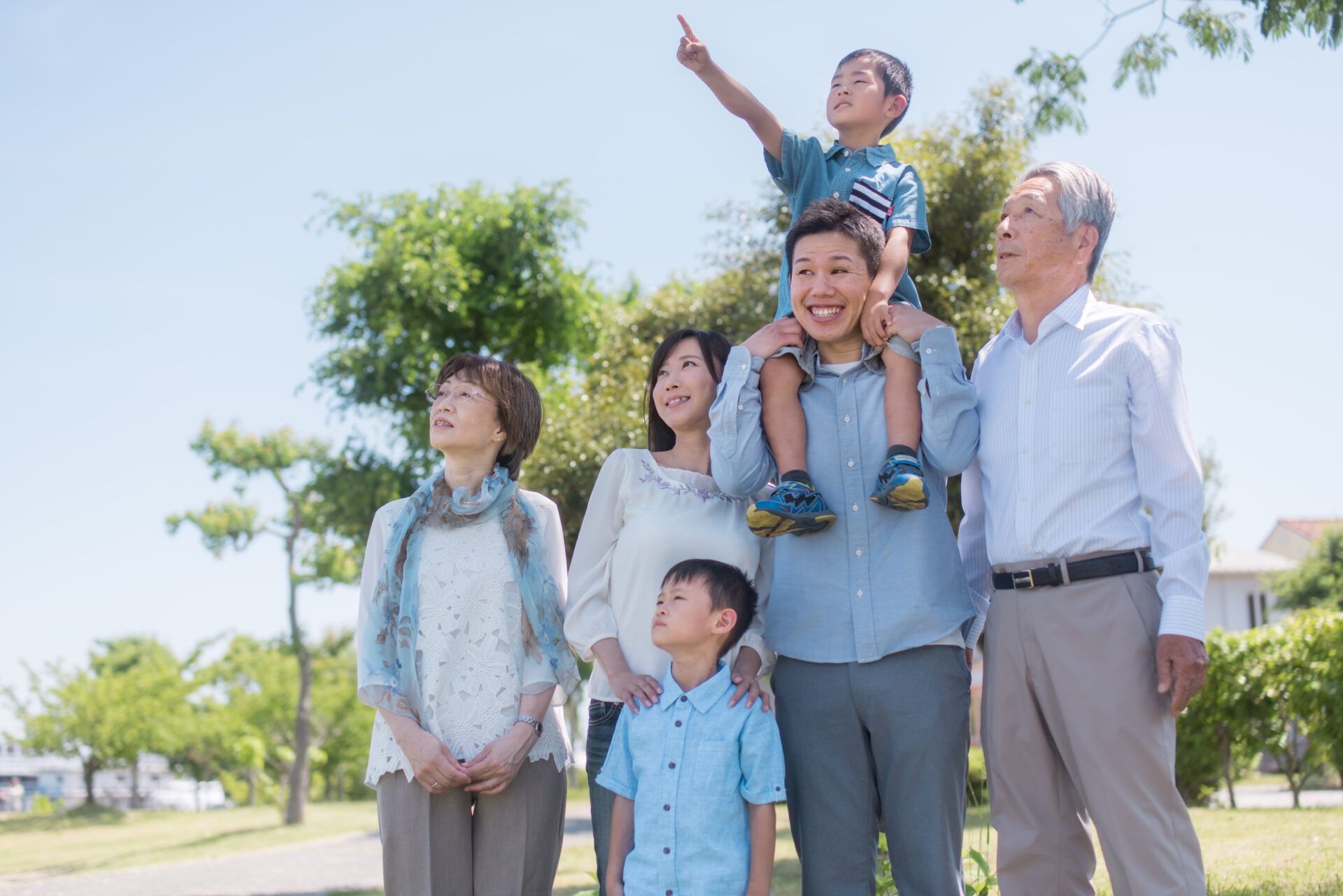 公園で息子を肩車するお父さんと三世代家族